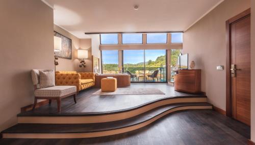 Orka Cove Hotel Penthouse & Suites Adults Only في فتحية: غرفة معيشة مع أريكة ونافذة