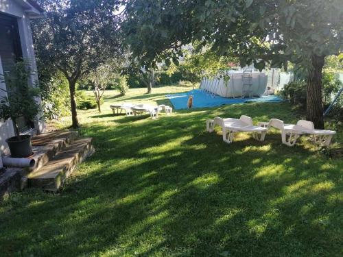 a group of picnic tables in a yard with a pool at Casa Anka in Gračišće