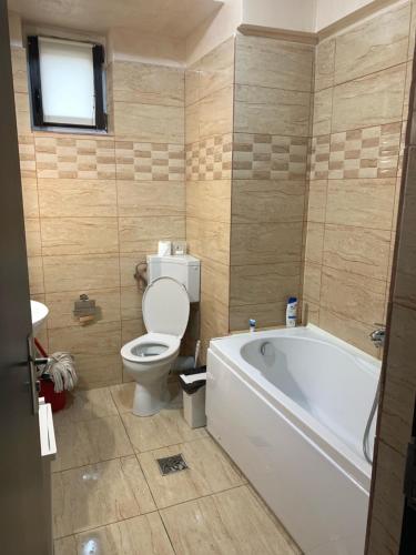 een badkamer met toilet en ligbad bij Ferdinand Apartment in Constanţa