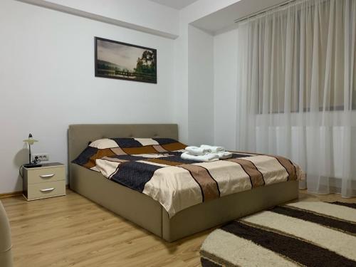 een slaapkamer met een bed, een ladekast en een raam bij Ferdinand Apartment in Constanţa