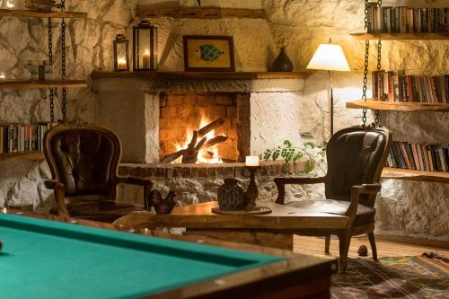 a living room with a pool table and a fireplace at Nautical Hotel in Faralya