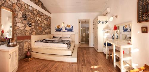 a bedroom with a bed and a stone wall at Nautical Hotel in Faralya