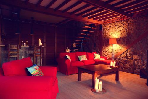 a living room with two red couches and a table at Nautical Hotel in Faralya