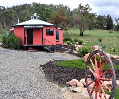 un edificio rojo con una rueda en un patio en A Stanthorpe Getaway, en Ballandean