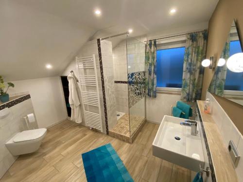 een badkamer met een douche, een toilet en een wastafel bij Gästehaus Beranek in Marktoberdorf