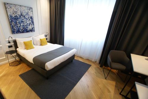 Un dormitorio con una cama con almohadas amarillas y una ventana en Fingerprint Tree Apartments - Delux en Zagreb