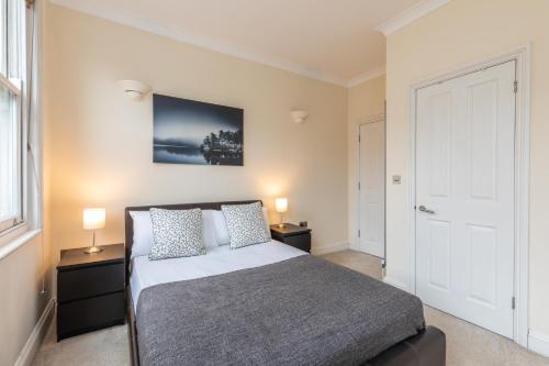 a bedroom with a bed with two night stands and two lamps at Camden City Living in London