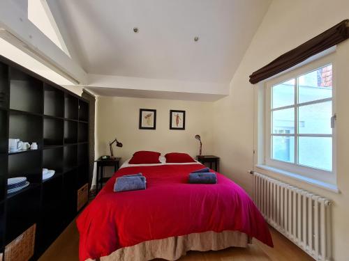 Un dormitorio con una gran cama roja con almohadas rojas en Maison Montana, en Bruselas