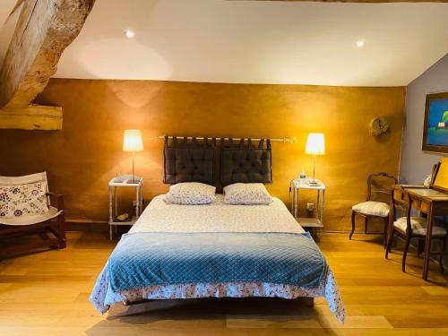 - une chambre avec un lit, deux tables et deux lampes dans l'établissement Le Fraysse, à Montdurausse