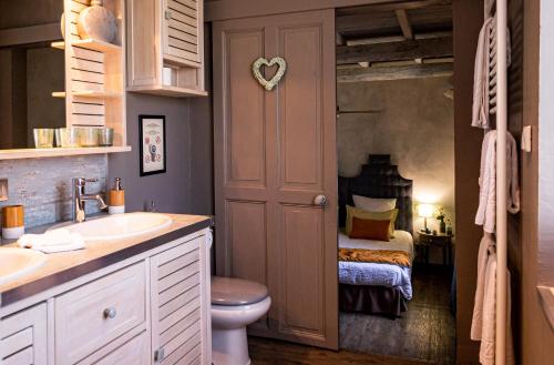 a bathroom with a sink and a toilet and a bedroom at Abacard Home Chambre d'Hôtes adult only in Roquemaure