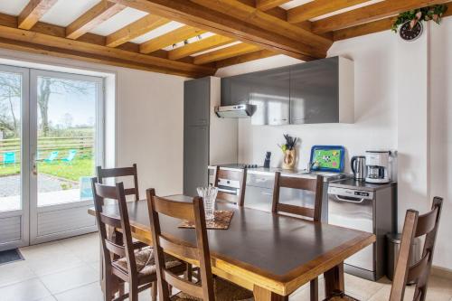 une cuisine avec une table en bois et une salle à manger dans l'établissement Maison charmante à Saint-Marcouf avec jardin., à Saint-Marcouf