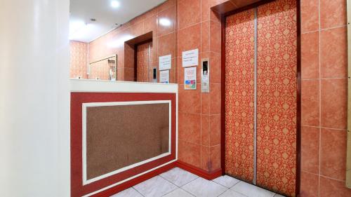 a bathroom with two shower stalls and a mirror at RedDoorz Plus @ Chinatown Binondo in Manila