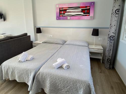 a bedroom with a bed with towels on it at Mda Playa del Cantal in Mojácar