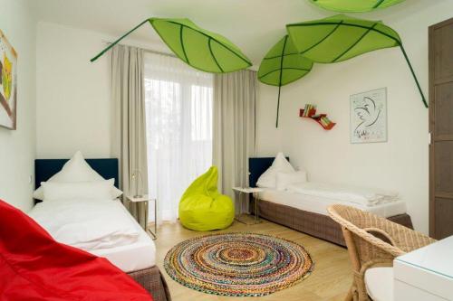 een woonkamer met 2 bedden en groene parasols bij Ostseedomizil La Mer in Börgerende-Rethwisch