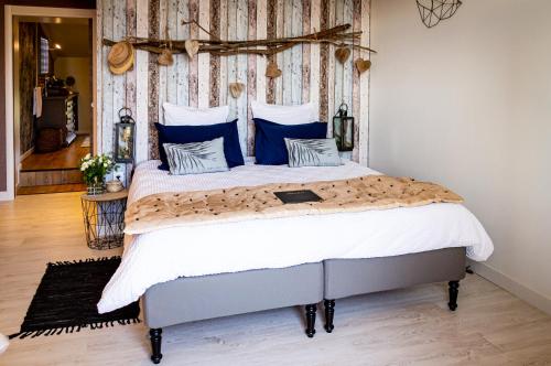 a bedroom with a large bed with blue pillows at Abacard Home Chambre d'Hôtes adult only in Roquemaure