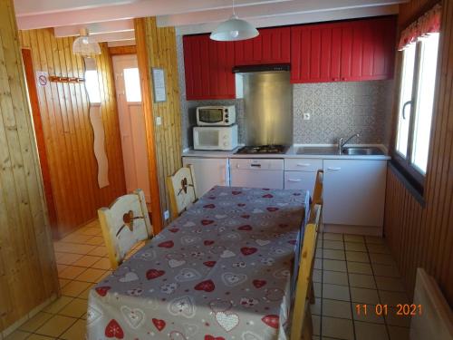 une petite cuisine avec une table et un micro-ondes dans l'établissement La Bresse Hautes Vosges Chalet Le Podent, à La Bresse