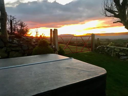 a picnic table with a sunset in the background at Mc Courts Cottage in Hilltown