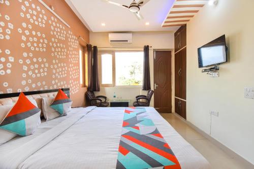 a bedroom with a bed with a tv on the wall at FabExpress Bzoie Heritage in Dehradun