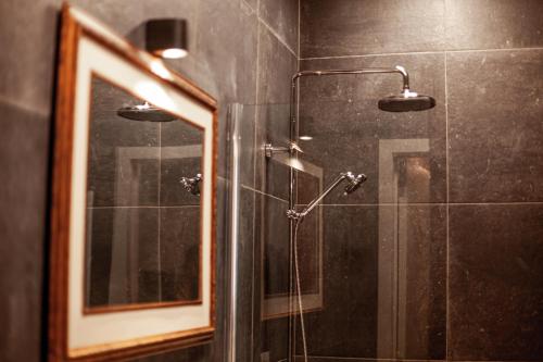 a bathroom with a shower and a mirror at Luxury Suites Palace by Rikas Hotels in Antwerp