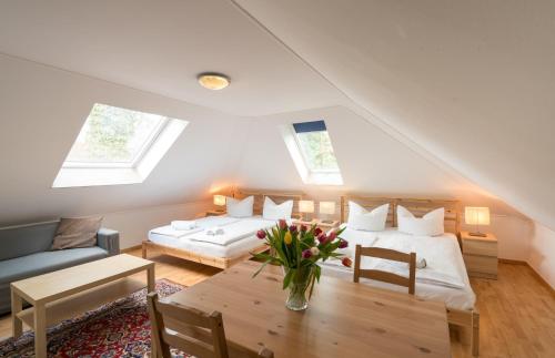 a attic bedroom with two beds and a table at guenstigschlafen24 – die günstige Alternative zum Hotel in Munich