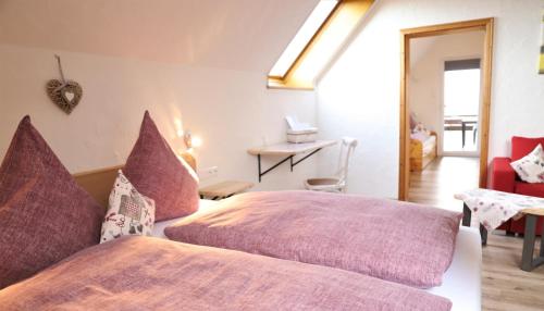 a bedroom with two beds with purple pillows at Landpension Pferdekoppel - B&B - Self Checkin in Seewald