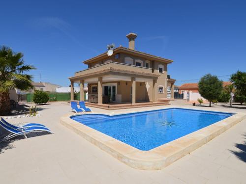 a villa with a swimming pool in front of a house at Superb villa for large families with large pool in San Fulgencio in La Marina