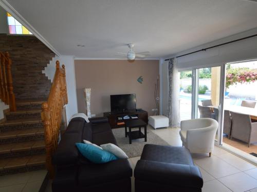 a living room with a couch and a tv at Superb villa for large families with large pool in San Fulgencio in La Marina