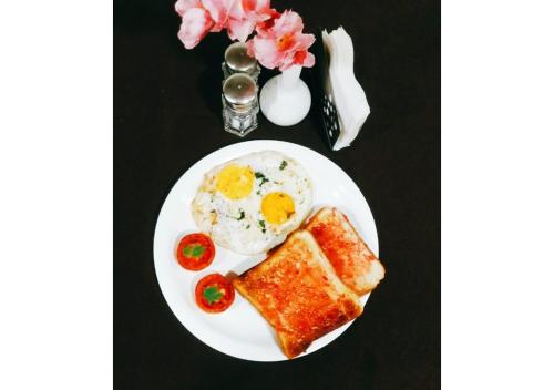 a plate of breakfast food with eggs and toast at Hotel Planet Four in Lonavala