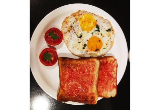a white plate with an egg and two slices of toast at Hotel Planet Four in Lonavala