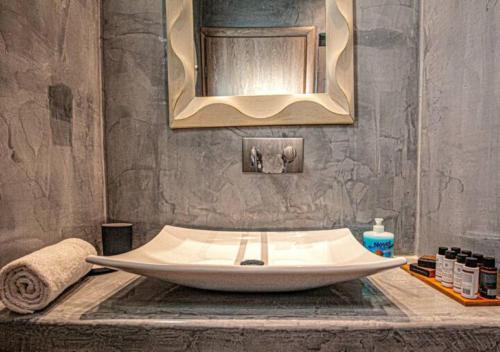 La salle de bains est pourvue d'un grand lavabo et d'un miroir. dans l'établissement DAFNES VILLA 1 Private Pool, à Perivolos
