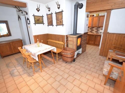 a kitchen with a table and a wood stove at small holiday home at the edge of the forest in Malá Skála