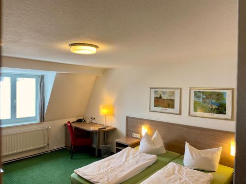 a hotel room with two beds and a desk at Gasthof Scharfe Kurve in Lützow