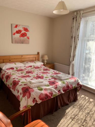 a bedroom with a bed with a floral bedspread at Kings Lodge Hotel in Great Yarmouth