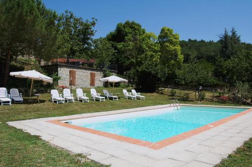 a swimming pool with chairs and umbrellas in a yard at Agriturismo Il Piano in Pratovecchio