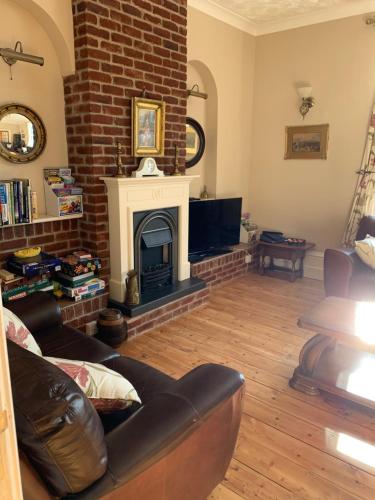a living room with a couch and a fireplace at Kings Lodge Hotel in Great Yarmouth