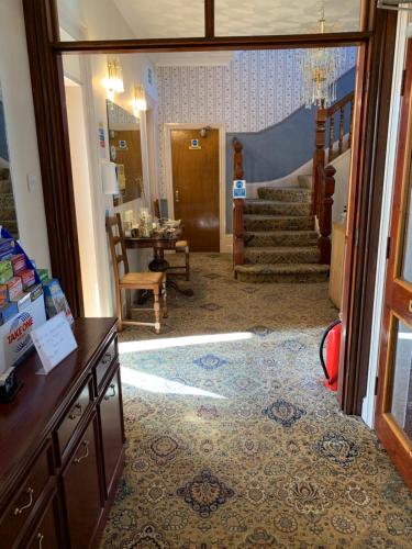 ein Wohnzimmer mit einer Treppe und ein Zimmer mit einem Flur in der Unterkunft Kings Lodge Hotel in Great Yarmouth