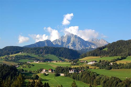 a view of a mountain range with green fields and trees at Ferienwohnung Kesselberg Edelweiss in Avelengo