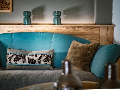 a blue couch with pillows in a living room at Alpenchalet Vils Tirol in Vils