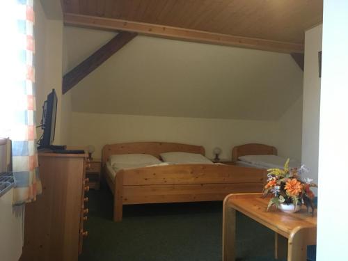 een slaapkamer met 2 bedden en een tafel met bloemen bij Penzion u Příhodů in Jesenice