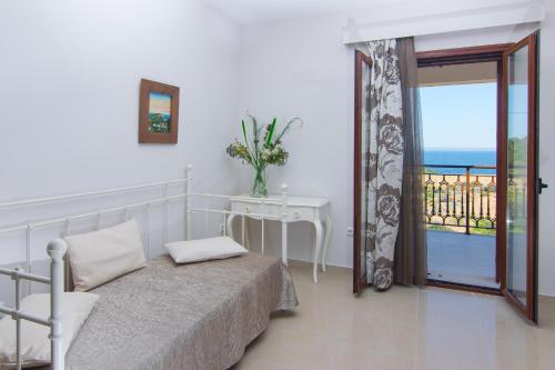 a bedroom with a bed and a view of the ocean at Armonia Seaside Villas in Vasilikos