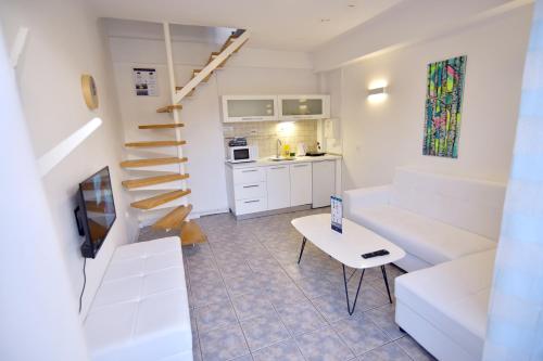 a small living room with a staircase and a table at Aloha Apartments with pool in Skopje