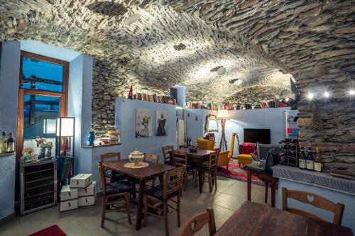 a restaurant with tables and chairs and a stone wall at Rifugio Lilla in La Thuile