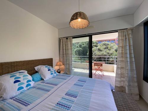 - une chambre avec un lit et un balcon dans l'établissement Coté Plage pied dans l'eau vue mer, à Propriano