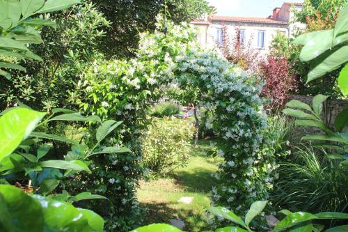 un jardín con un arco de flores y plantas en Maison Prades Chambre d'Hôtes en Prades