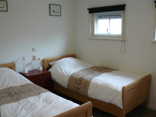 una camera con due letti e una finestra di Wagenschuur a Emst