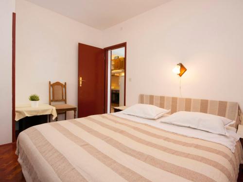 ロゴズニッツァにあるApartments Škarpa 1601のベッドルーム1室(大型ベッド1台、ストライプ毛布付)