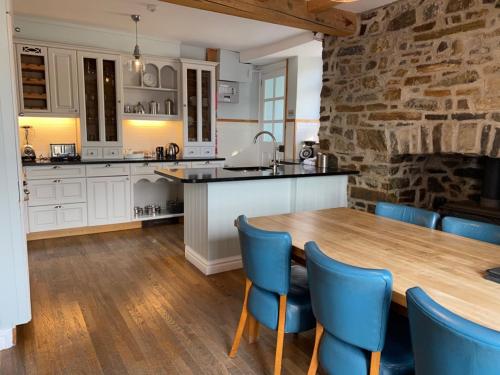 una cucina con tavolo in legno e sedie blu di Harbourmaster Hotel a Aberaeron