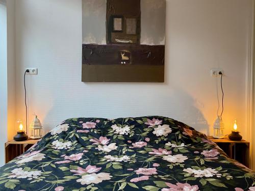 Una cama con una manta con flores. en Het Hoekje - 2 bedroom family friendly city home, en Groninga
