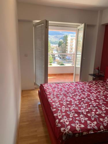 une chambre avec un lit rouge et une grande fenêtre dans l'établissement Apartment Alex, à Ohrid
