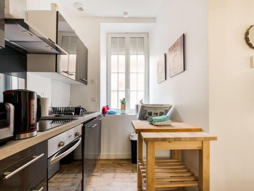 une petite cuisine avec une table en bois. dans l'établissement Apartment in Isigny near Cotentin Marshes, à Isigny-sur-Mer